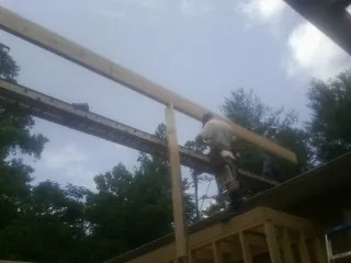 Carpenter setting a ridge beam over a new addition frame — Ice Dam Removal by Roofing Brothers in West Branch