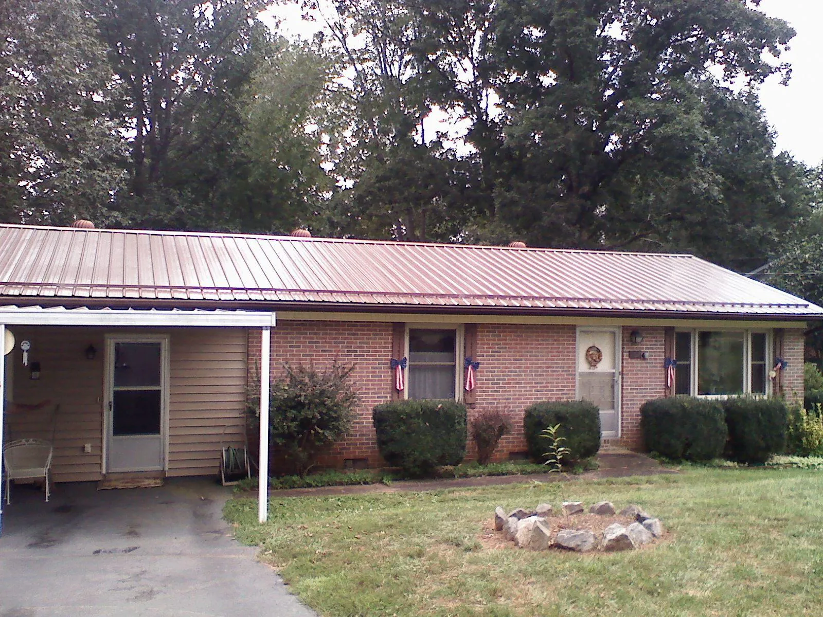 Bronze metal roof and carport on a brick ranch home — Roof Repair work by our crew in West Branch