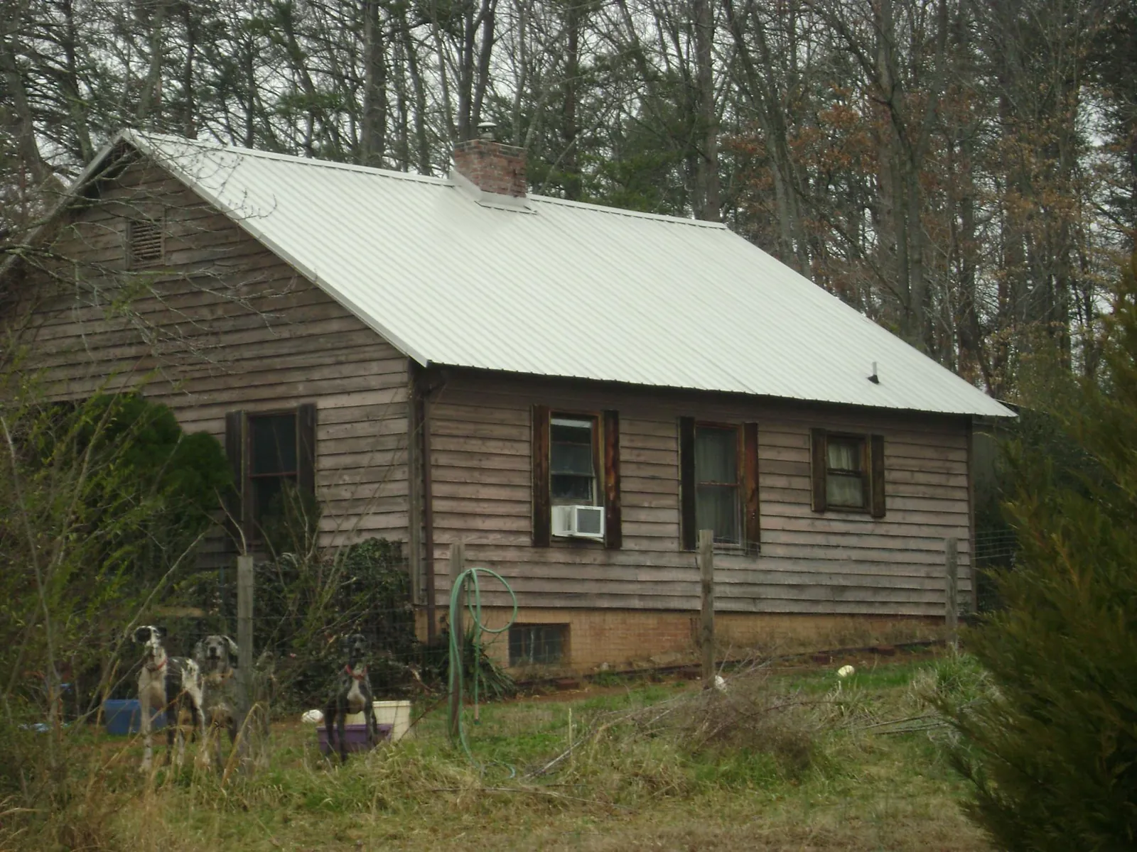 White metal roof on an old wood sided farmhouse, from a Metal Roof Installation job in West Branch